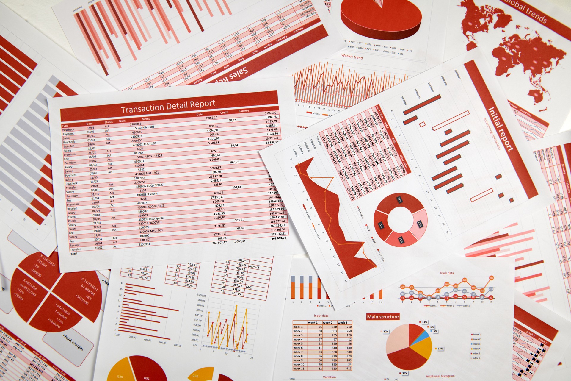 Business reports, data tables and charts - directly above view of office table workspace.
